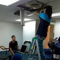 Technicians installing a cassette ceiling unit in an office