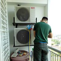Arif Aircond technician gauging twin outdoor condenser units on a balcony