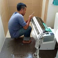 Technician servicing a wall split unit in a utility area