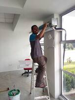 Technician on a ladder installing a wall unit in a new interior
